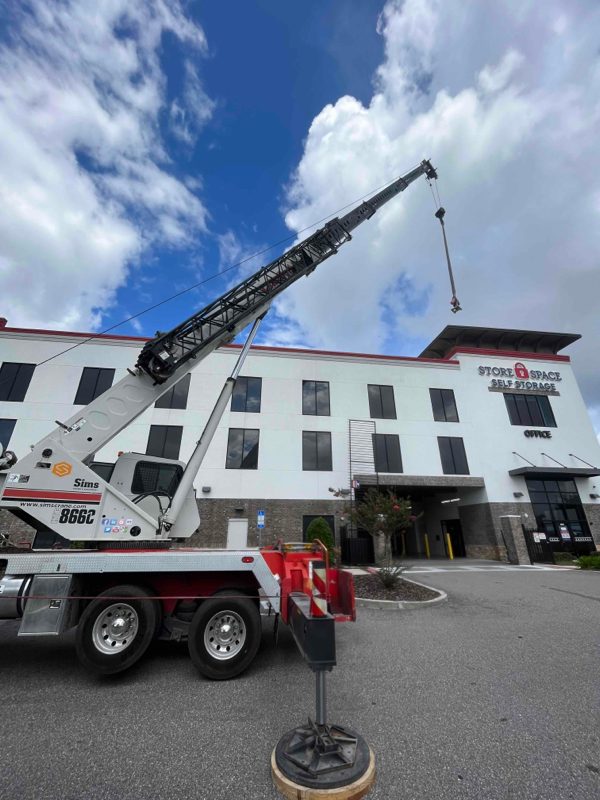 Crane lifting HVAC equipment at a self-storage facility — SBS-NC commercial install