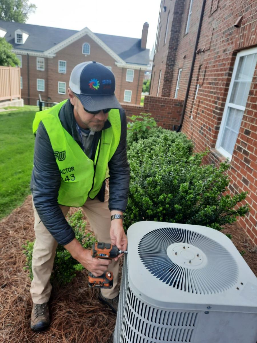 SBS-NC technician performing preventative maintenance on a condenser